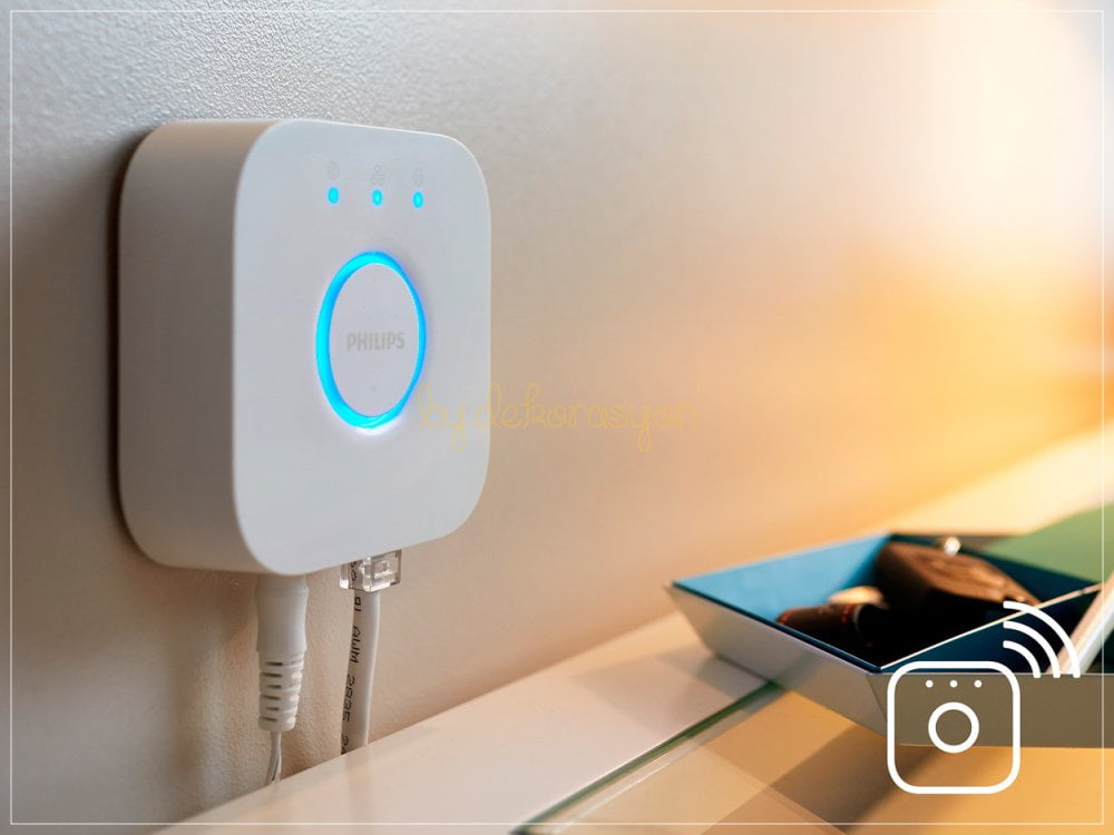 Modemin yanında duran beyaz Philips Hue Bridge cihazı